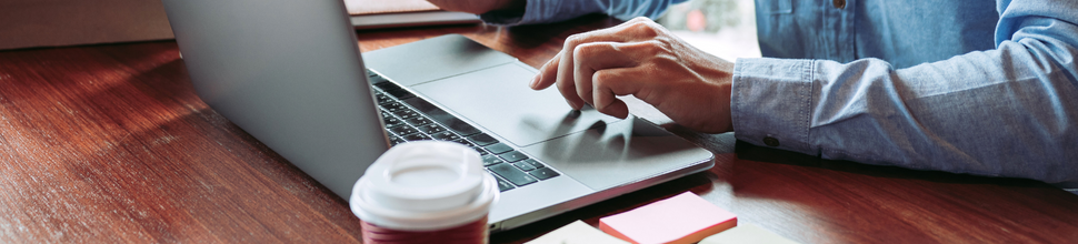 Male using laptop with coffee and sticky notes on table